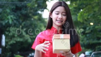 泰国青少年美女穿着中国服装，新年快乐，打开盒子礼物，不开心。